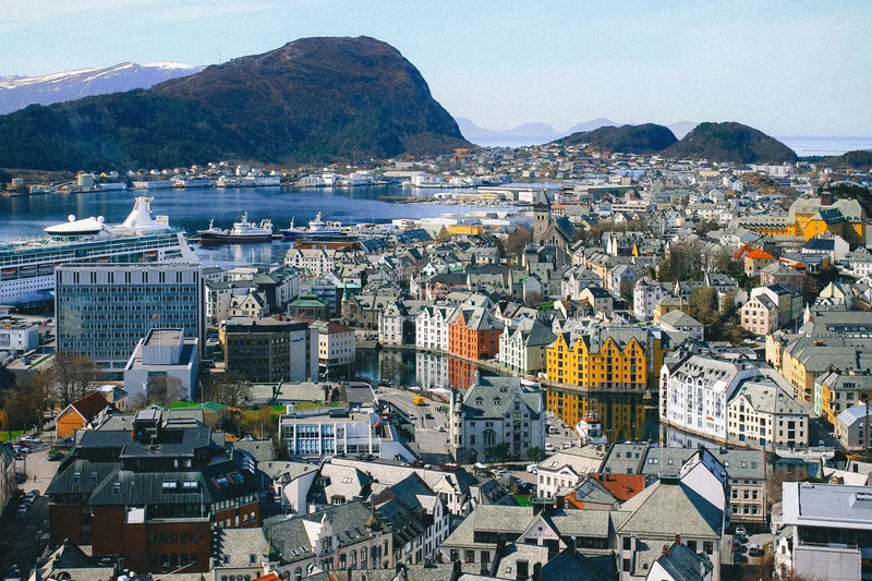 Ålesund from above, Art Nouveau buildings along the Brosundet canal and a cruise ship moored in the harbour.