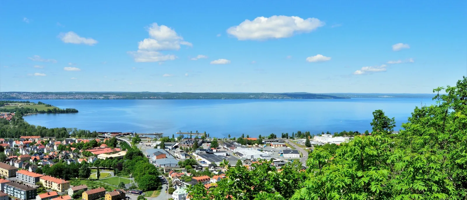 A Norwegian coastal town from the air, the harbour and the streets laid out along the shoreline with open sea beyond.